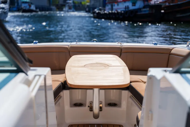  Yacht Photos Pics Luxurious Sea Ray boat interior with wooden table and leather seating on a sunny day.