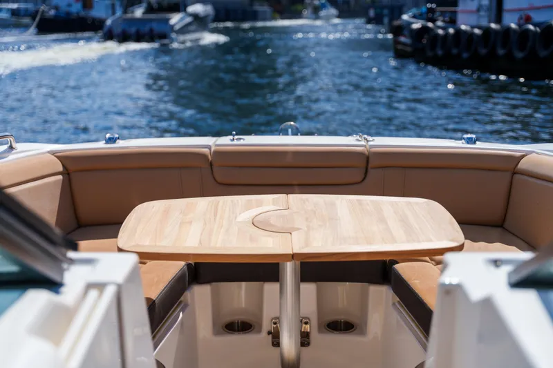  Yacht Photos Pics Luxury Sea Ray boat interior with wooden table and cushioned seating, overlooking calm water.