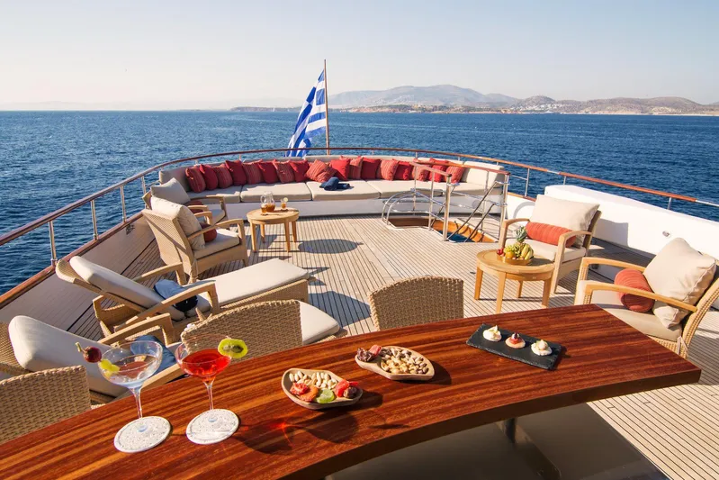 Parvati Yacht Photos Pics Luxurious 1979 CRN Displacement yacht deck with elegant seating, drinks, and snacks, overlooking the sea.