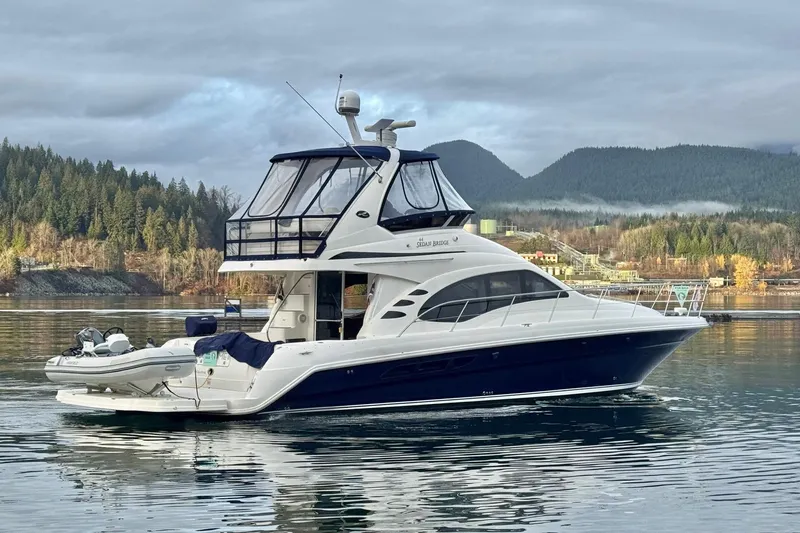 Covetime II Yacht Photos Pics 2006 Sea Ray 44 Sedan Bridge yacht on calm water with scenic mountain backdrop.