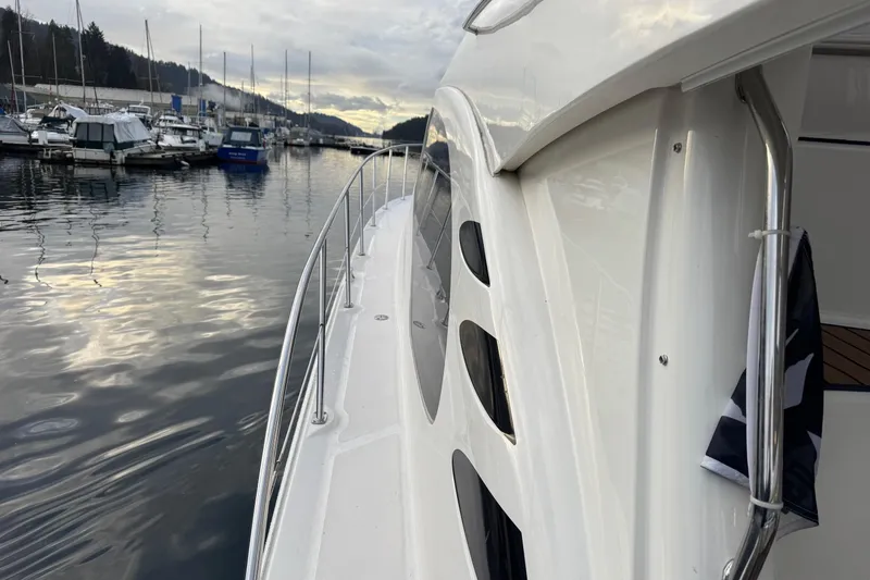 Covetime II Yacht Photos Pics 2006 Sea Ray 44 Sedan Bridge yacht docked at a marina, reflecting on calm water.