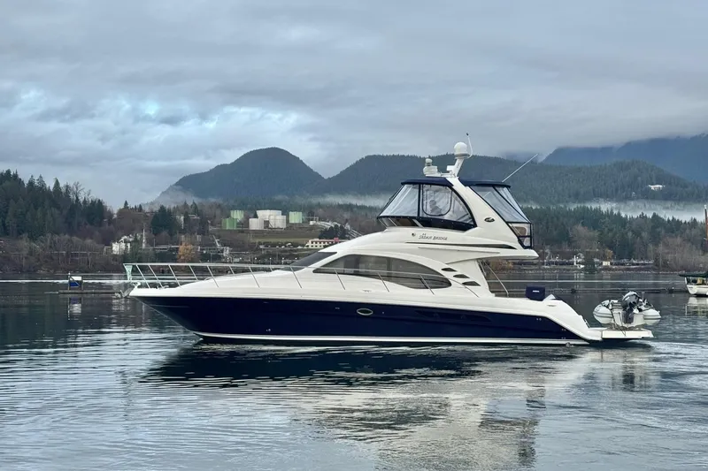 Covetime II Yacht Photos Pics 2006 Sea Ray 44 Sedan Bridge yacht on calm water with mountainous backdrop.