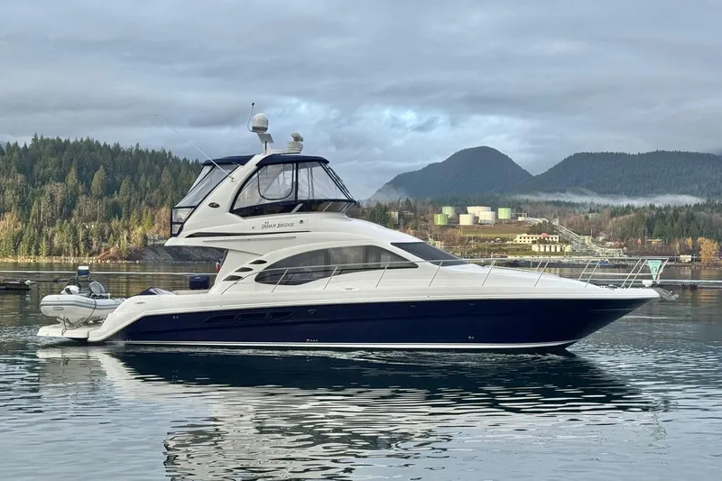Covetime II Yacht Photos Pics 2006 Sea Ray 44 Sedan Bridge yacht on calm water with scenic mountain backdrop.