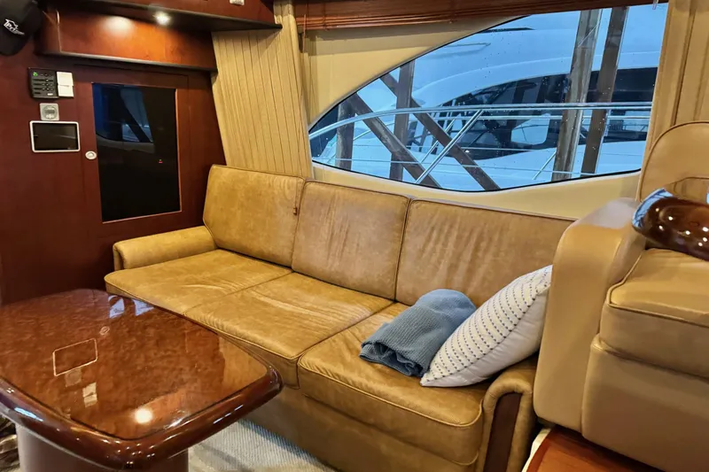 Covetime II Yacht Photos Pics Luxurious interior of 2006 Sea Ray 44 Sedan Bridge yacht with leather sofa and wooden table.