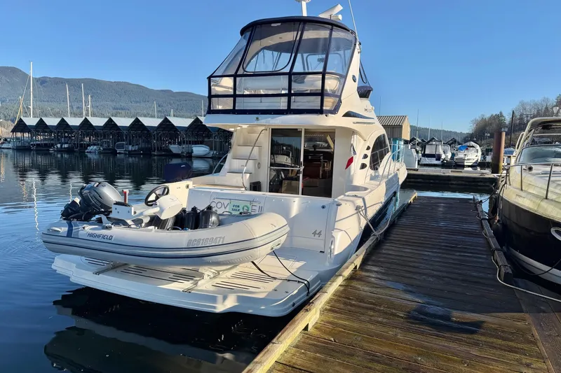 Covetime II Yacht Photos Pics 2006 Sea Ray 44 Sedan Bridge yacht docked with inflatable boat, marina background.