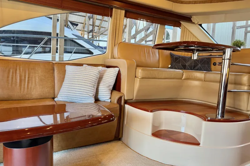 Covetime II Yacht Photos Pics Luxurious interior of 2006 Sea Ray 44 Sedan Bridge yacht with leather seating and elegant table.