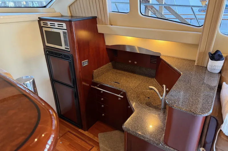 Covetime II Yacht Photos Pics Luxurious 2006 Sea Ray 44 Sedan Bridge yacht kitchen with modern appliances and elegant wood finish.