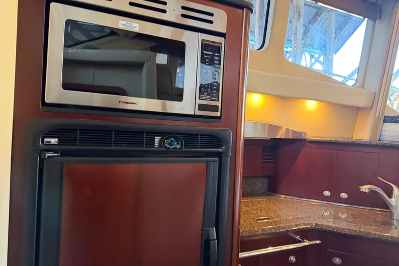 Covetime II Yacht Photos Pics 2006 Sea Ray 44 Sedan Bridge kitchen with microwave, fridge, and granite countertops.