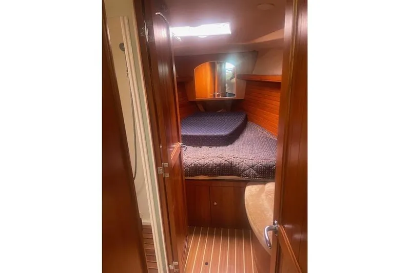 The Boat Yacht Photos Pics 2007 Marlow-Hunter 45CC yacht cabin with wooden interior and cozy bed.
