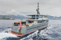 Custom 2024 K584 Hull 2 yacht cruising on open sea with mountainous coastline in background.