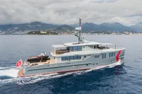 Custom 2024 K584 Hull 2 yacht cruising on open water with scenic mountain backdrop.