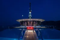 Luxurious 2024 Custom K584 Hull 2 yacht at night, illuminated deck, serene ocean backdrop.