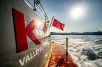 Custom K584 Hull 2 yacht, Valletta, 2024, cruising with flag, sunlit sea view.