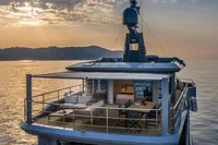 Luxurious 2024 Custom K584 Hull 2 yacht at sunset, featuring elegant outdoor seating and dining area.
