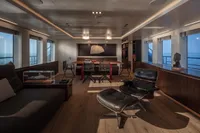 Luxurious yacht interior with modern furnishings, featuring a lounge chair and panoramic ocean views.