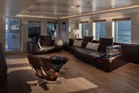 Luxurious yacht interior with modern seating, large windows, and wooden flooring, Custom K584 Hull 2, 2024.