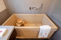 Modern wooden bathtub with towels and a wooden bucket, Custom K584 Hull 2, 2024 model.
