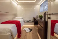 Luxurious yacht cabin with twin beds, red accents, and modern decor, 2024 Custom K584 Hull 2.