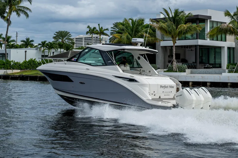  Yacht Photos Pics 2023 Sea Ray Sundancer 320 Outboard cruising on water near modern waterfront homes.
