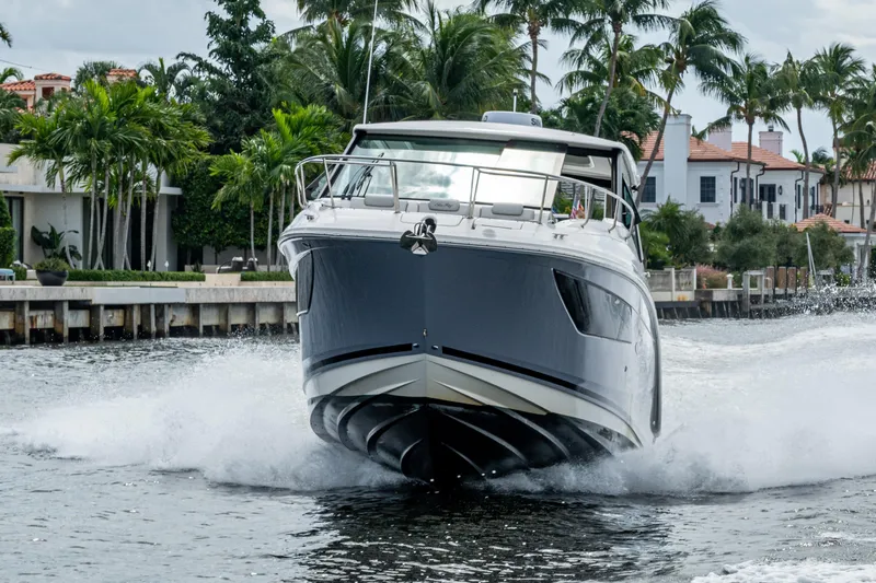  Yacht Photos Pics 2023 Sea Ray Sundancer 320 Outboard cruising on a scenic waterway with palm trees.