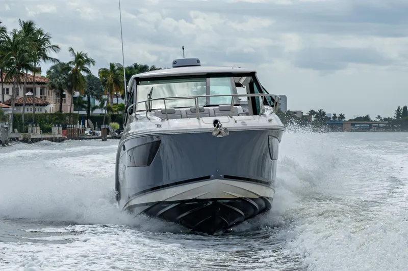  Yacht Photos Pics 2023 Sea Ray Sundancer 320 Outboard cruising on water near palm trees.