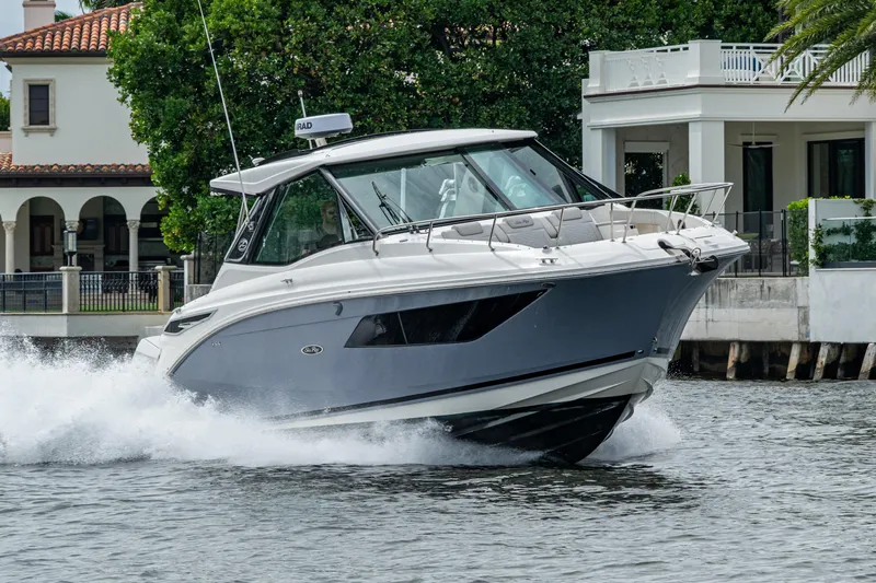  Yacht Photos Pics 2023 Sea Ray Sundancer 320 Outboard cruising near waterfront homes.