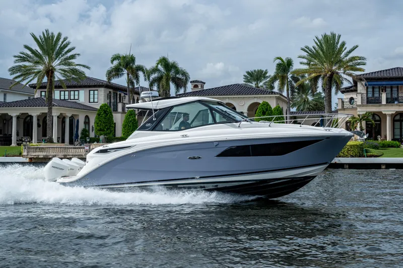  Yacht Photos Pics 2023 Sea Ray Sundancer 320 Outboard cruising on water near luxury waterfront homes.
