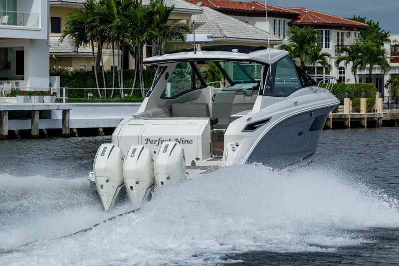  Yacht Photos Pics 2023 Sea Ray Sundancer 320 Outboard cruising on water near luxury homes.