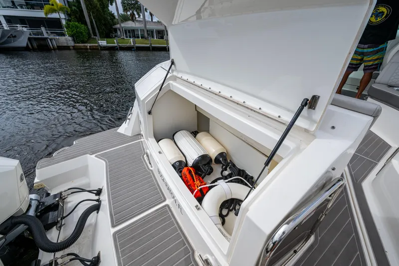  Yacht Photos Pics 2023 Sea Ray Sundancer 320 Outboard storage compartment with fenders and equipment by the water.
