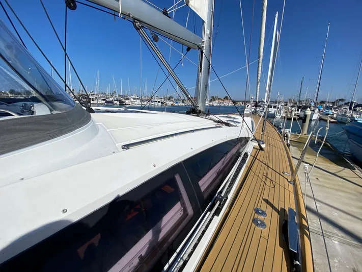  Yacht Photos Pics 2013 Jeanneau 57 sailboat deck with marina view, clear blue sky.