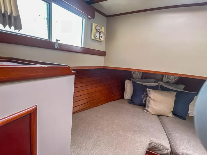 Tallulah Yacht Photos Pics Cozy cabin interior of 1989 Grand Banks 42 Classic with cushions and wooden accents.