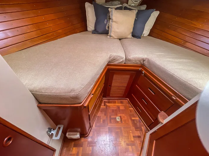 Tallulah Yacht Photos Pics 1989 Grand Banks 42 Classic cabin with wooden interior and cozy bedding.