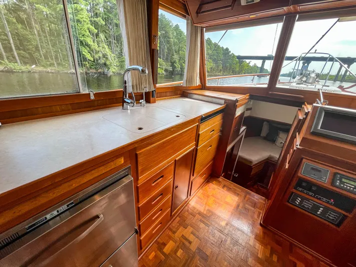 Tallulah Yacht Photos Pics 1989 Grand Banks 42 Classic yacht interior with wood cabinetry and scenic waterway view.