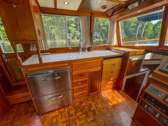 Tallulah Yacht Photos Pics Interior of 1989 Grand Banks 42 Classic yacht with wooden cabinetry and large windows.