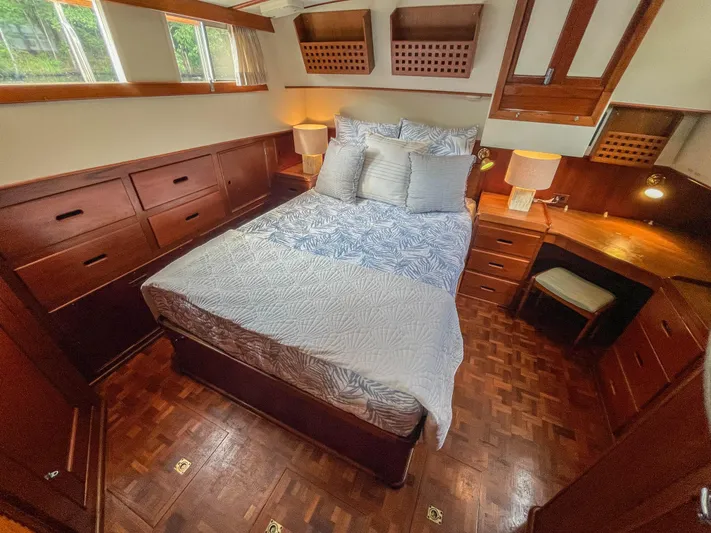 Tallulah Yacht Photos Pics Cozy bedroom in 1989 Grand Banks 42 Classic yacht with wooden furnishings and natural light.