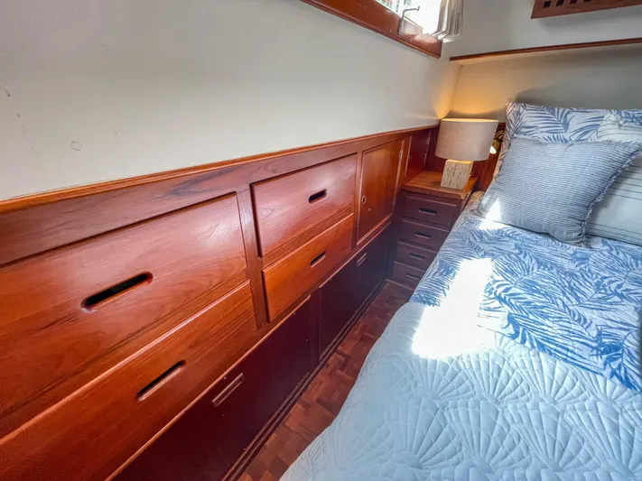 Tallulah Yacht Photos Pics Wooden cabin interior of 1989 Grand Banks 42 Classic yacht with bed and storage drawers.