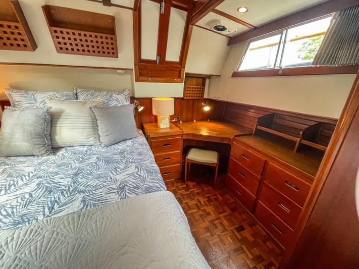 Tallulah Yacht Photos Pics Cozy bedroom in 1989 Grand Banks 42 Classic yacht with wooden furnishings and natural light.