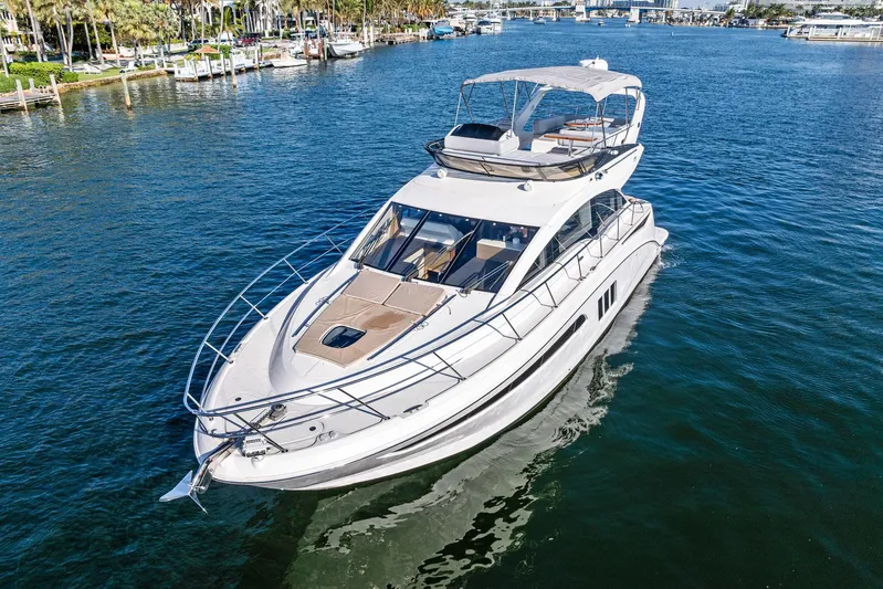 Guilty Pleasure Yacht Photos Pics 2014 Sea Ray 510 Fly yacht cruising on a sunny day in a marina.