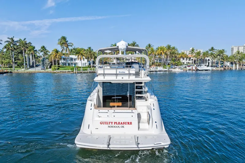 Guilty Pleasure Yacht Photos Pics 2014 Sea Ray 510 Fly yacht on water, palm trees in background.