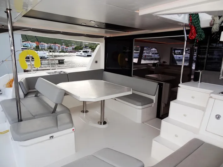 Good Times Yacht Photos Pics 2020 Leopard 45 yacht interior with spacious seating and dining area, docked at marina.