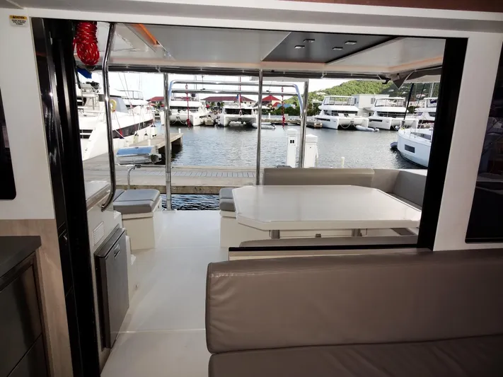 Good Times Yacht Photos Pics Interior view of a 2020 Leopard 45 yacht, featuring a spacious seating area and marina backdrop.