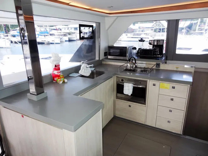 Good Times Yacht Photos Pics Modern kitchen interior on a 2020 Leopard 45 catamaran, featuring appliances and marina view.