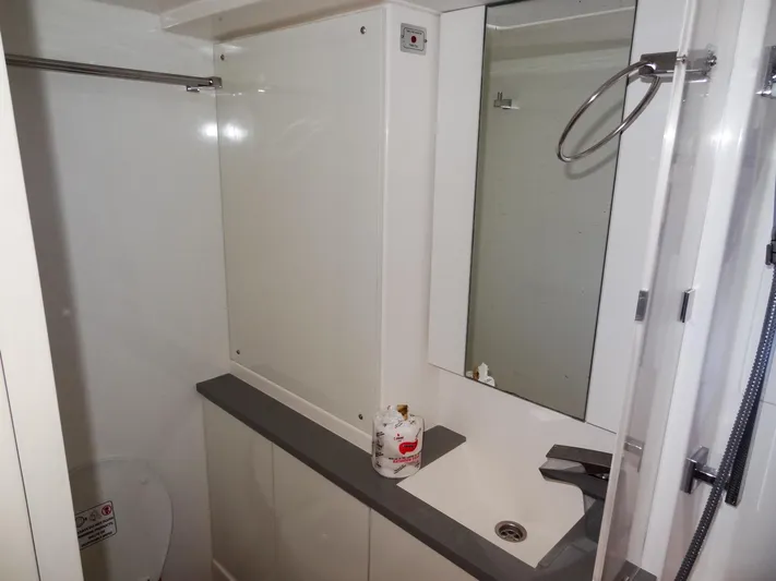 Good Times Yacht Photos Pics Modern bathroom interior on a 2020 Leopard 45 yacht, featuring a sink and mirror.