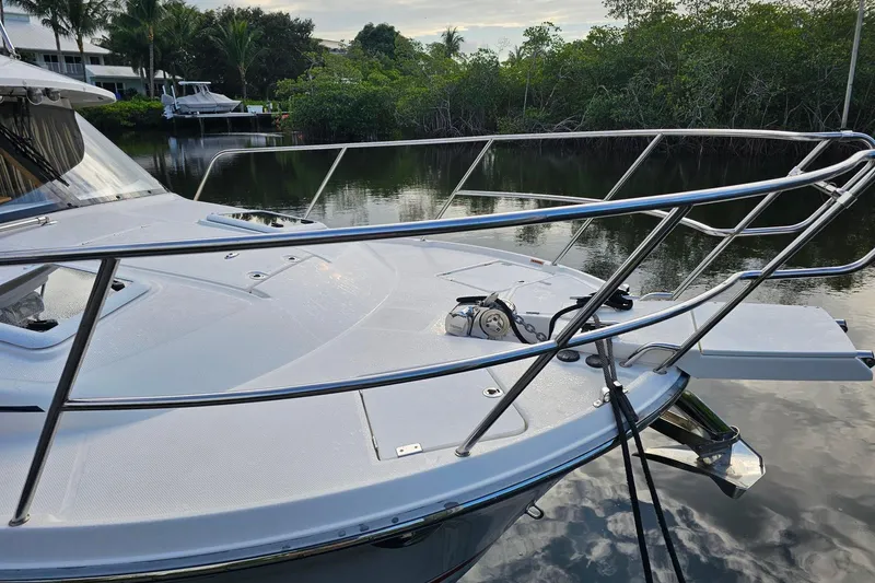 Frisky Yacht Photos Pics 2022 Cuwater C-32-CB boat docked on calm water with lush greenery.