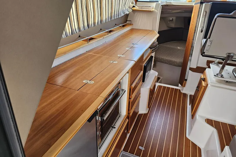 Frisky Yacht Photos Pics 2022 Cuwater C-32-CB boat interior with wood finish and modern amenities.