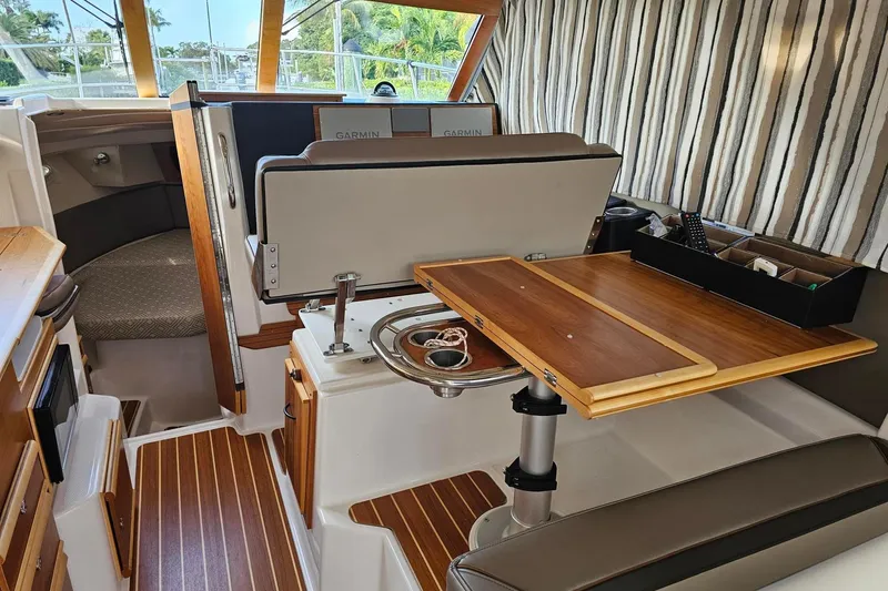 Frisky Yacht Photos Pics Interior of 2022 Cuwater C-32-CB boat with wooden table and striped curtains.