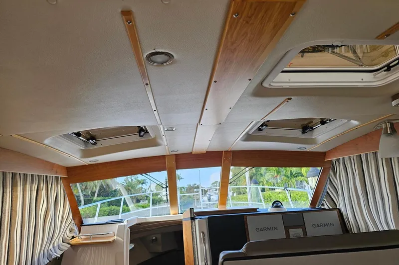 Frisky Yacht Photos Pics Interior view of 2022 Cuwater C-32-CB boat with striped curtains and Garmin equipment.