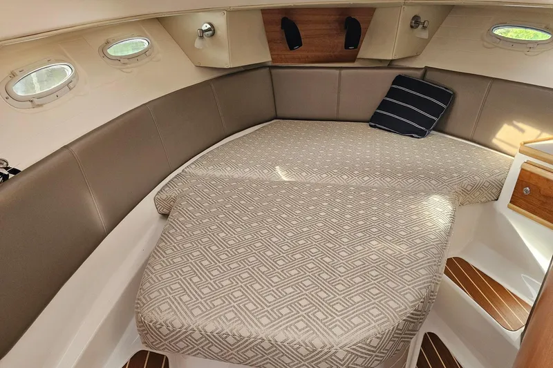 Frisky Yacht Photos Pics 2022 Cuwater C-32-CB cabin interior with patterned bedding and porthole windows.