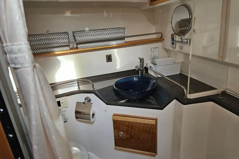 Frisky Yacht Photos Pics Compact bathroom in 2022 Cuwater C-32-CB boat with modern sink and mirror.