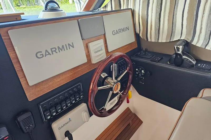 Frisky Yacht Photos Pics Cuwater C-32-CB 2022 boat dashboard with Garmin navigation system and wooden steering wheel.